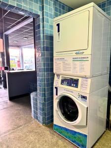 a washer and dryer in a room with blue tiles at City Studios Apartamentos Novos em Natal in Natal