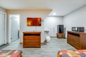 a hotel room with a desk and a tv at Ski, Explore, Bring Pets! Studio 5 Mi to Pine Knob in City in the Village of Clarkson