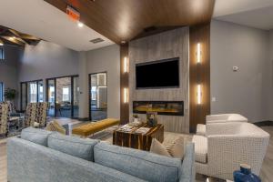 a living room with two blue couches and a tv at Landing Incredible 1BD Pool Gym in Katy