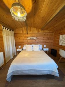 une chambre avec un grand lit dans une pièce en bois dans l'établissement Le Chalet des Pins - La Forge De Clermont, à Clermont
