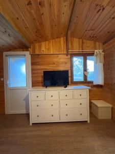 Cette chambre dispose d'une commode et d'une télévision. dans l'établissement Le Chalet des Pins - La Forge De Clermont, à Clermont 4 autres photos