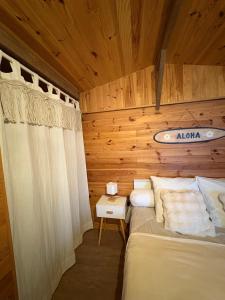 une chambre avec un lit et un mur en bois dans l'établissement Le Chalet des Pins - La Forge De Clermont, à Clermont
