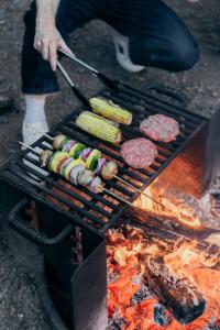 een persoon die vlees en groenten kookt op een grill bij Postcard Cabins Eastern Catskills, Outdoor Collection by Marriott Bonvoy in Catskill