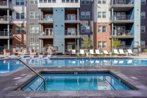 a swimming pool with chairs and a building at Landing Stylish 2BD Gym Pool in Colorado Springs