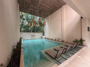 una piscina con sedie e un tavolo in un edificio di Balam Tulum a Cedro