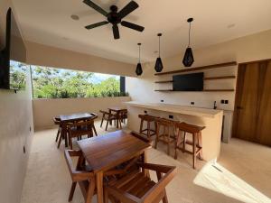 una cucina con tavoli e sedie in legno e un ventilatore a soffitto di Balam Tulum a Cedro