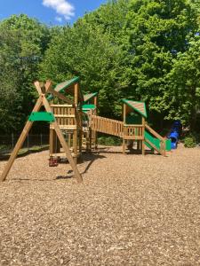 a playground with wooden play equipment in a park at Sequoia Duo 2 chalets voisins, familles,amis,détente in Durbuy