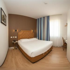 a bedroom with a large bed and a desk at Hotel Boutique Holitel in Santiago