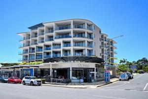 a large apartment building with cars parked in front of it at Ocean Views Retreat, Caloundra in Caloundra