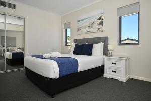 a bedroom with a king sized bed and a desk at Ocean Views Retreat, Caloundra in Caloundra +20 photos
