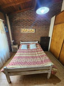 a bedroom with a large bed in a brick wall at Lo de Capra! in Santa Clara del Mar