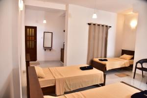 een ziekenhuiskamer met twee bedden en een spiegel bij Misty Clouds Homestay in Kandy