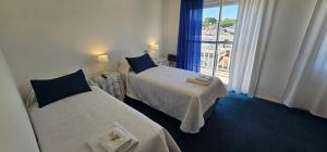 una camera d'albergo con due letti e una finestra di Hotel Soleares a Mar del Plata