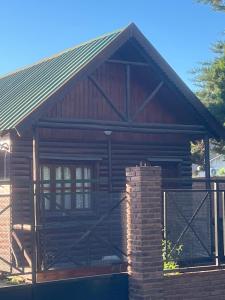 a log cabin with a fence in front of it at Cabaña, Sol y Paz in Lima