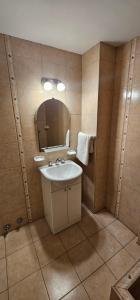 un bagno con lavandino e specchio di Hotel Soleares a Mar del Plata Altre 211 foto