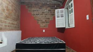 a room with a bed and a brick wall at Sitiolosbragas in Caetanópolis