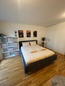 a bedroom with a large bed and a wooden floor at Studio moderne avec parking in Delémont