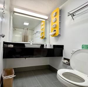 een badkamer met een toilet, een wastafel en een spiegel bij Motel 6-New Stanton, PA in New Stanton +17 foto's