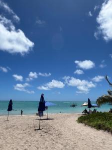 a beach with umbrellas and people in the water at Flats Brisa Antunes in Maragogi