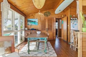 a kitchen with a table and chairs in a room at Gorgeous Beach House in Pukehina