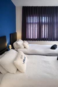 two beds in a hotel room with white pillows at The Stadium Rooms Elegant and Comfy Stay in London