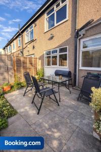 a patio with a table and chairs in front of a house at The Stadium Rooms Elegant and Comfy Stay in London