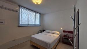 a small bedroom with a bed and a window at Loft 201 H54 Waiwa host in Bucaramanga