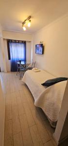 una camera da letto con un letto, un tavolo e delle sedie di Hotel Soleares a Mar del Plata