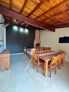 a dining room with a table and chairs and a fireplace at Casa Completa Para Dias Perfeitos in Olímpia