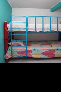een slaapkamer met 2 stapelbedden en een kleurrijke sprei bij Comfortable and quiet with a pool in Barrio Nuevo