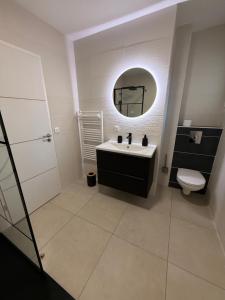a bathroom with a sink and a toilet and a mirror at Dom & Val in Tournan-en-Brie +28 photos