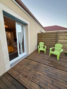 two green chairs on the deck of a house at Dom & Val in Tournan-en-Brie