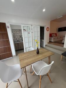 ein Esszimmer mit einem Holztisch und weißen Stühlen in der Unterkunft SAN FRANCISCO in Comodoro Rivadavia