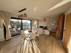 a living room with a table and chairs and a couch at Casa Loua in Blankenberge +10 photos