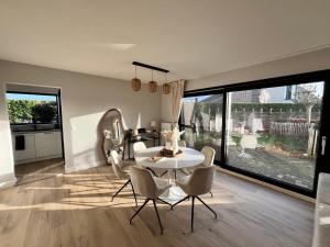 a dining room with a white table and chairs at Casa Loua in Blankenberge