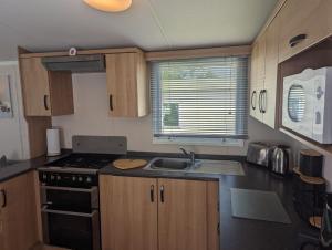 a small kitchen with a stove and a sink at Denny's Holiday Homes in Blackpool +3 photos