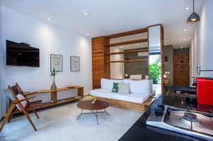 een woonkamer met een witte bank en een keuken bij Flat Pitanga in Camburi