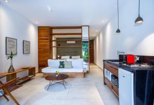 een slaapkamer met een bed en een keuken met een tafel bij Flat Pitanga in Camburi