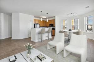 un soggiorno a pianta aperta con mobili bianchi e una cucina di Landing Chic 2BD Gym Pool a Frederick