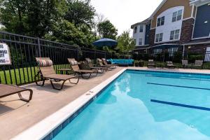 una piscina con lettini e un ombrellone di Landing Chic 2BD Gym Pool a Frederick Altre 6 foto