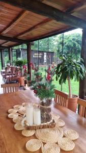 een houten tafel met borden en kaarsen erop bij Chácara Alci Guedes in São Gabriel