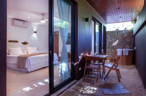 een slaapkamer met een bed en een tafel en stoelen bij Flat Pitanga in Camburi +166 foto's