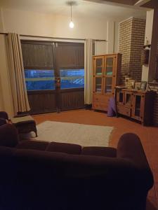 ein Wohnzimmer mit Couch und großem Fenster in der Unterkunft Casa no Farol de Santa Marta in Laguna