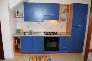 a kitchen with blue cabinets and a sink at Appartamento con Giardino - WIFI in San Vito lo Capo