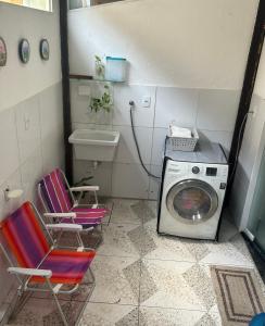 een wasruimte met 2 stoelen en een wasmachine bij Arembepe Vilage Duplex in Camaçari