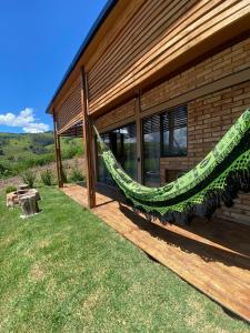 een hangmat aan de zijkant van een huis bij Pousada privativa mirante do sol in Socorro