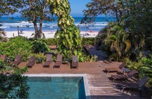 een resort met een zwembad en een strand bij Flat Pitanga in Camburi