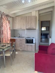 une cuisine avec un canapé rouge et une table et une cuisine dans l'établissement vasiliki's Apartments, à Dhímitra