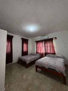 una camera da letto con due letti e due finestre di Casa de Playa Elsa a La Vigueta