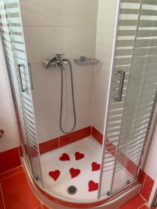 une douche avec des coeurs rouges sur le sol dans l'établissement vasiliki's Apartments, à Dhímitra